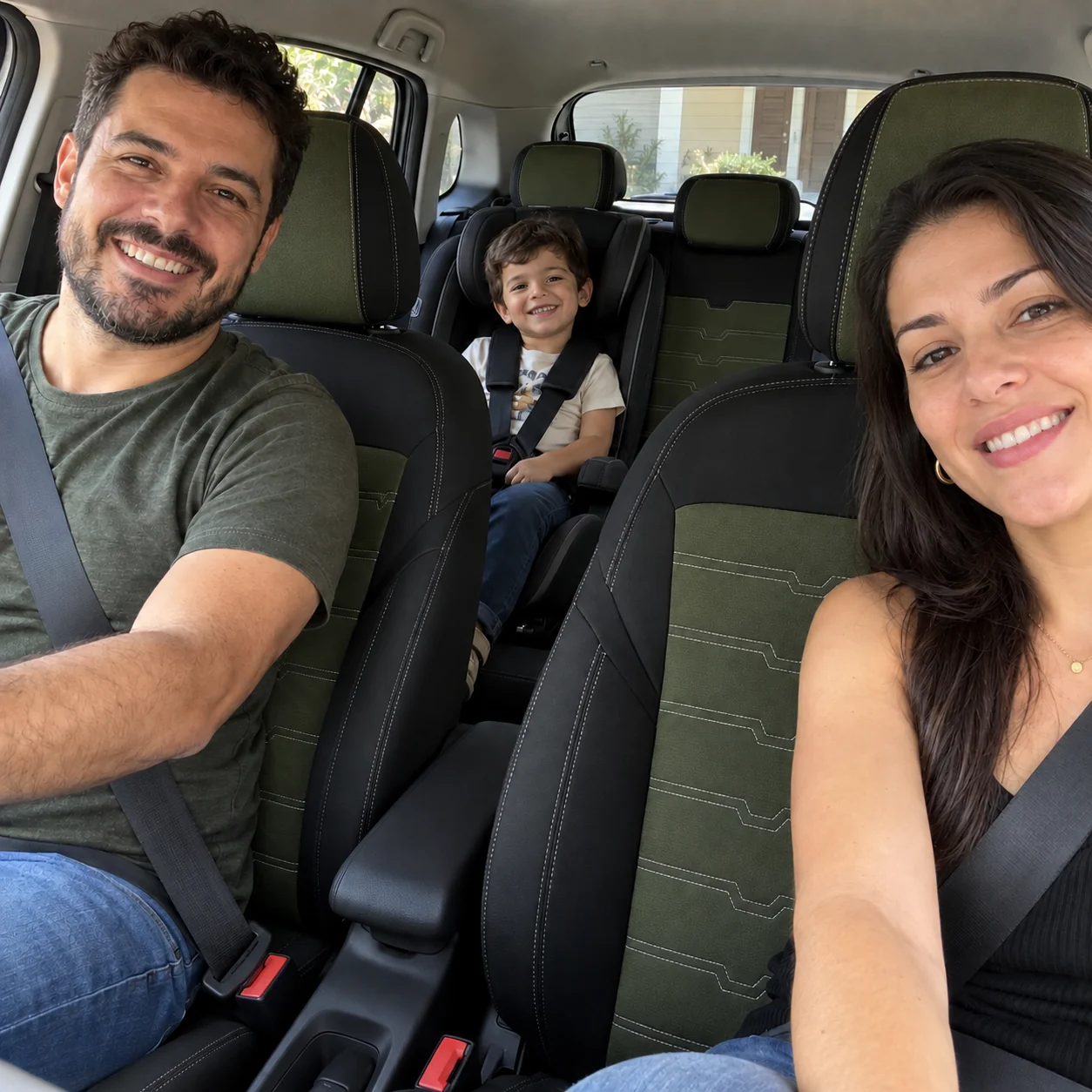 Família de três dentro do carro com capas de banco em preto e verde oliva e costura branca